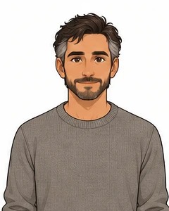 Eli, with graying brown hair, a short beard, and a warm-gray sweater.